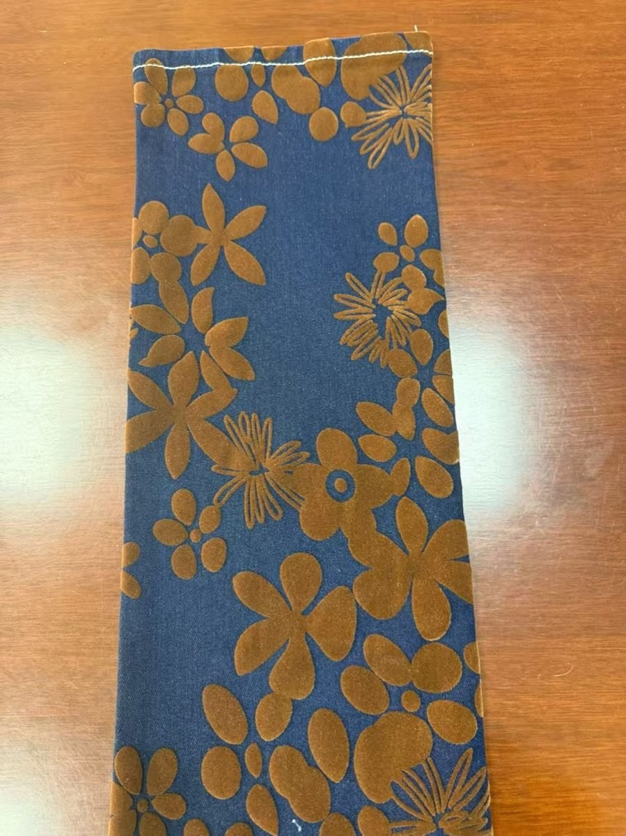 Floral flocked denim pattern on blue base fabric
